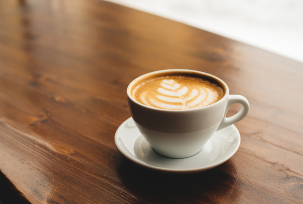 Tasse de café blanche posée sur une table en bois. Pour boire sa dose de caféine chaque matin!